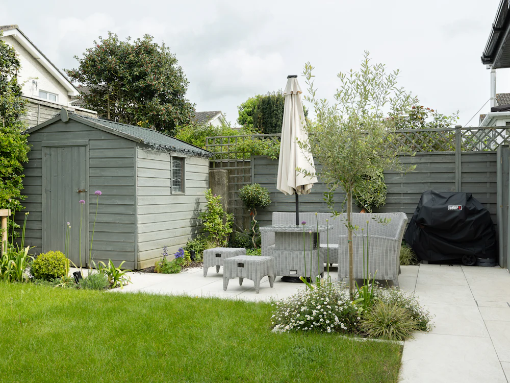 After: paved outdoor room with new lawn, planting and a shed