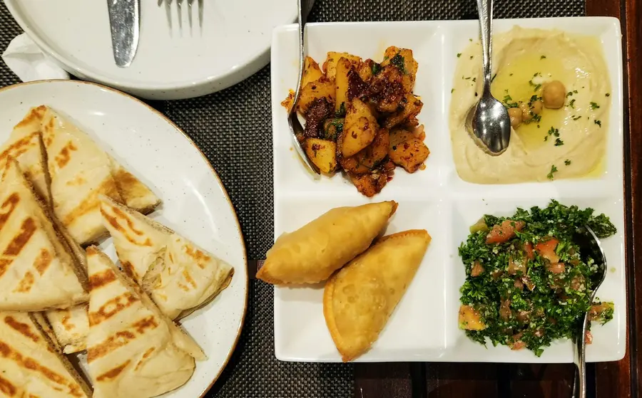 A platter of hummus, tabouli, pastries and grilled bread