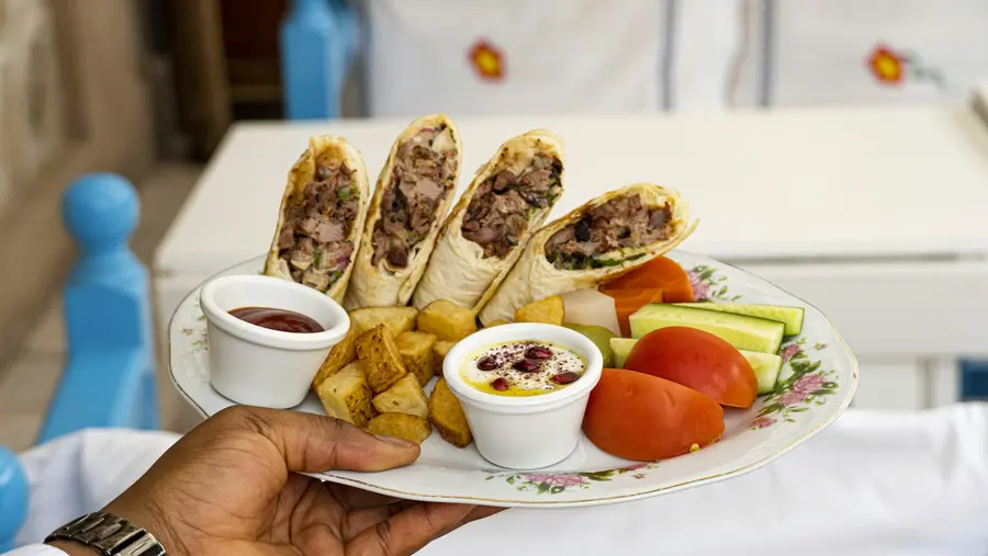 A plate of cut wraps with chips and dips
