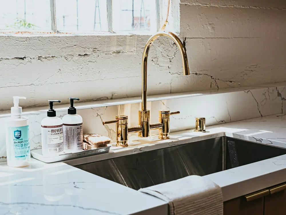 Brass kitchen mixer and filter tap over a stainless undermount sink