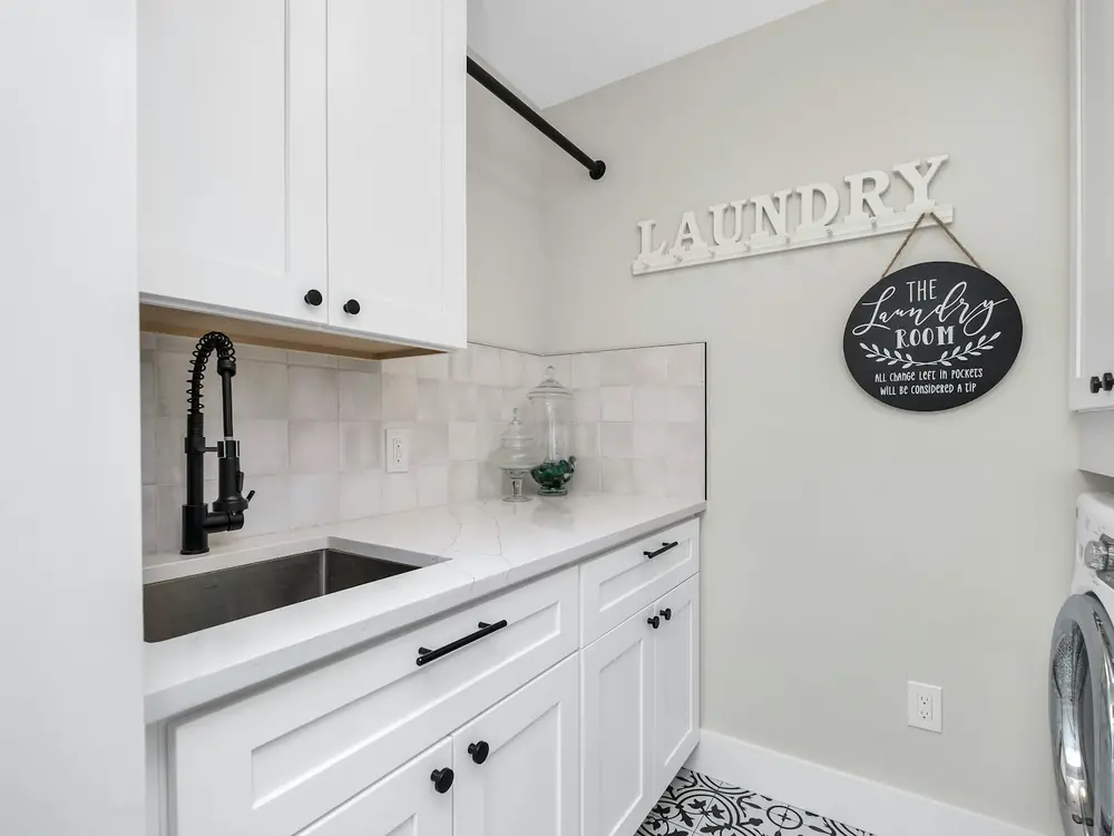 White shaker laundry with black gooseneck tap and undermount sink