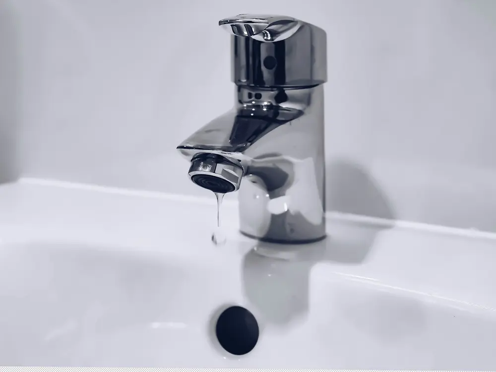 Satin-finish single-lever basin mixer over a white basin