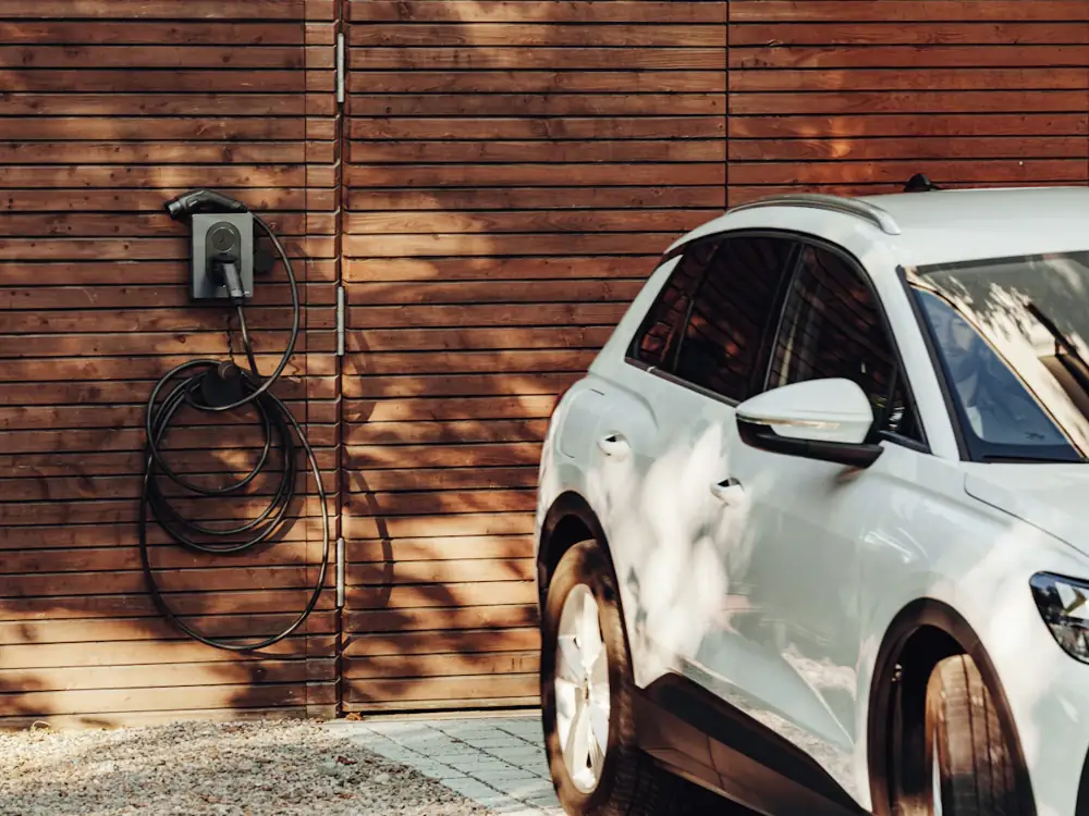 Wall-mounted EV charger next to a white electric car
