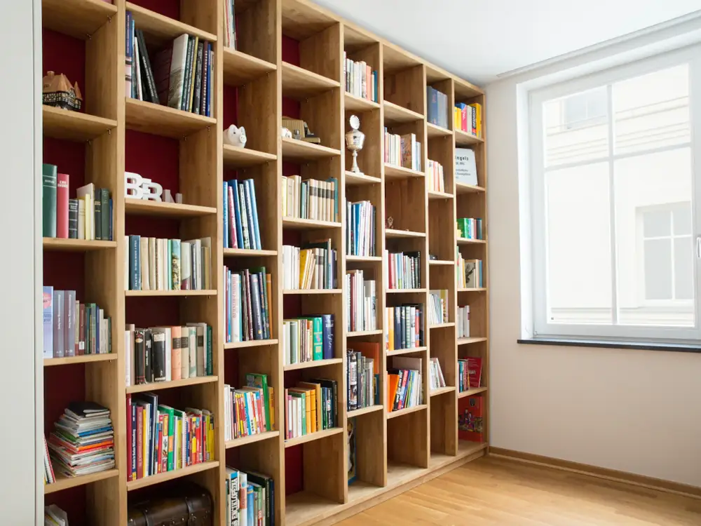 Wall of built-in timber bookshelves beside a window