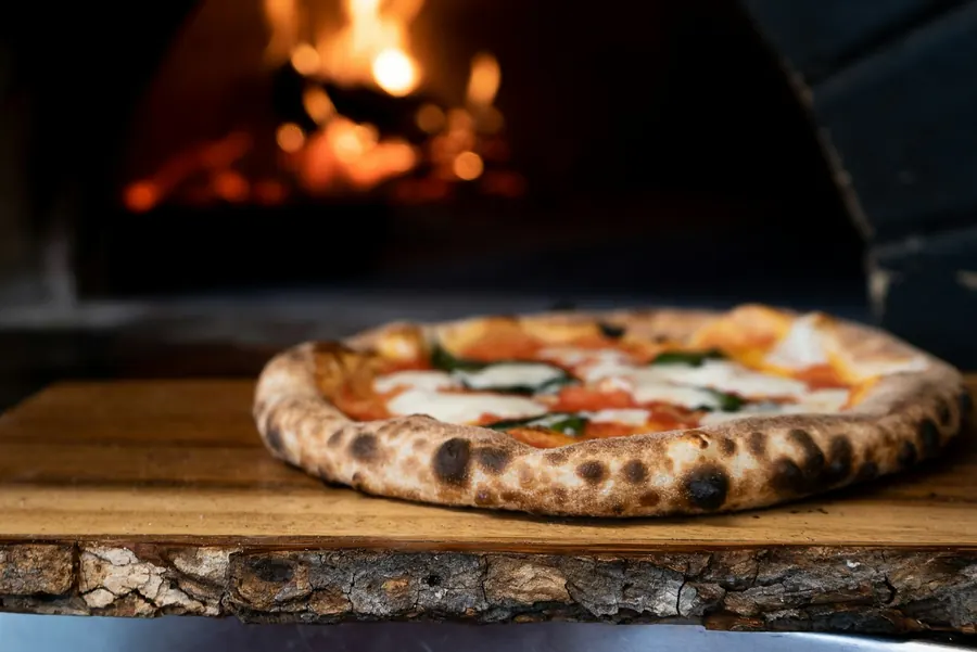 Bufala margherita on a timber board in front of the oven