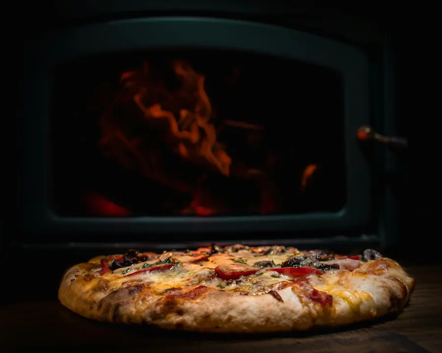 A capricciosa with mushrooms and olives in front of the fire