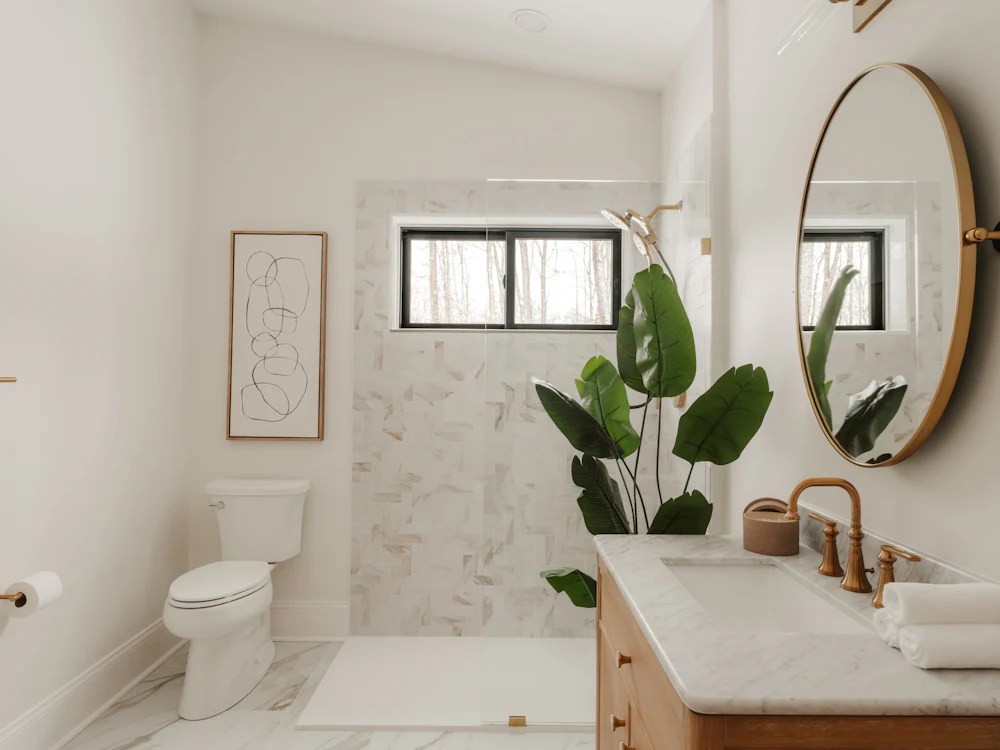 Spotless bathroom with round mirror and marble tiles
