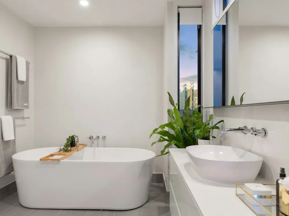 White family bathroom with a freestanding bath, vessel basin and wall-mounted tapware