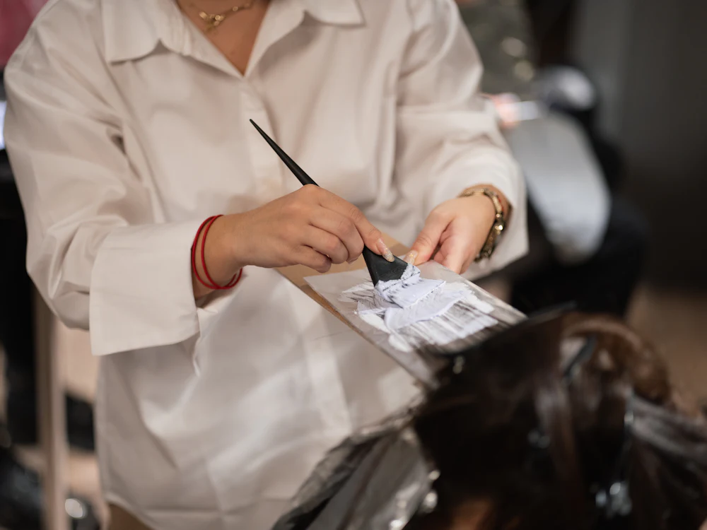 Colourist painting colour onto hair over a foil