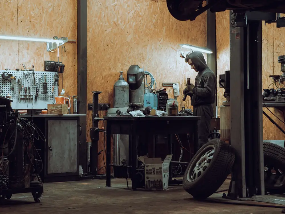 Inside the tyre workshop, with a hoist, tool wall and wheels ready to fit
