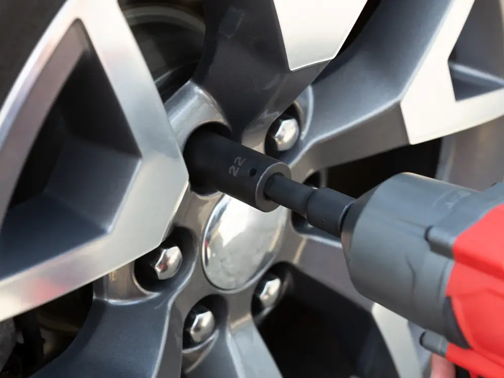 Impact wrench tightening wheel nuts on an alloy wheel