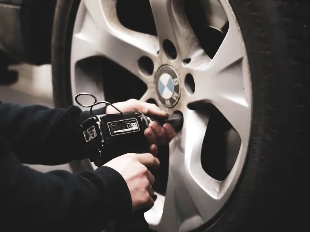 Technician tightening wheel nuts on a silver mag wheel
