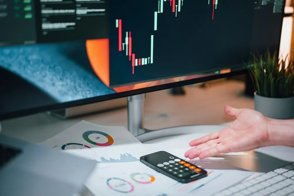 Phone calculator on a desk with printed charts