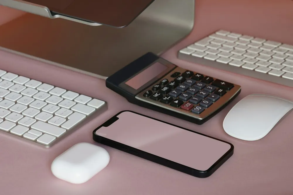 Calculator, phone and keyboards on a tidy desk