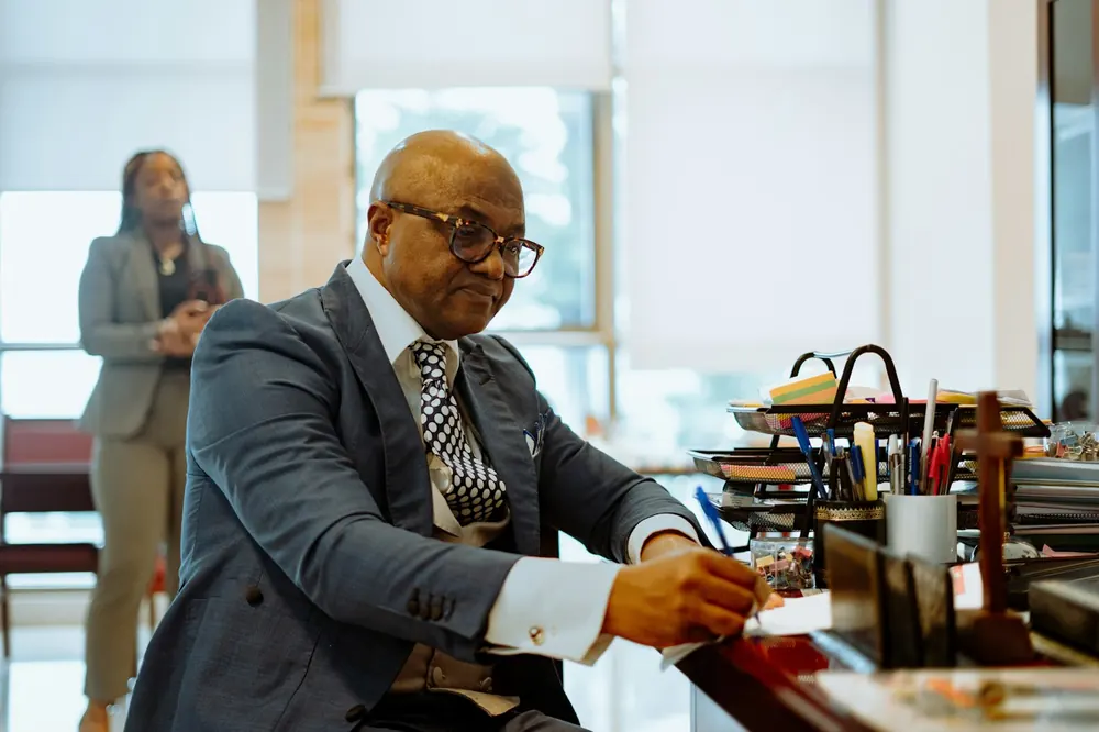 Accountant writing notes at a busy office desk