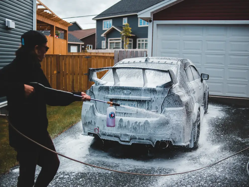 Josh foam-washing a car in a driveway