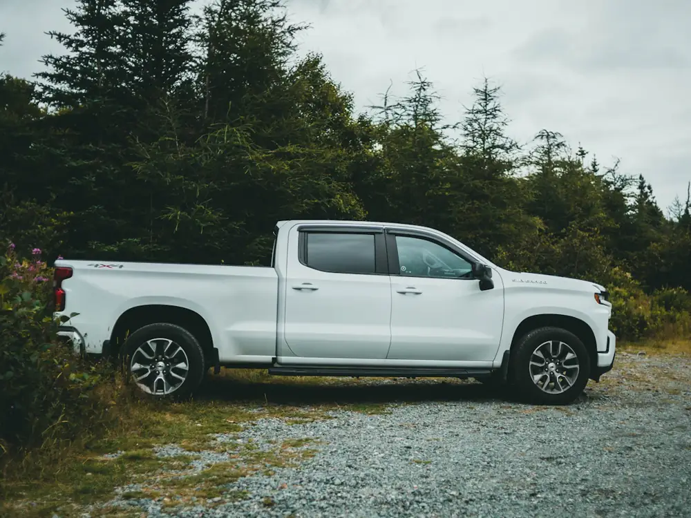 A white work ute parked on gravel