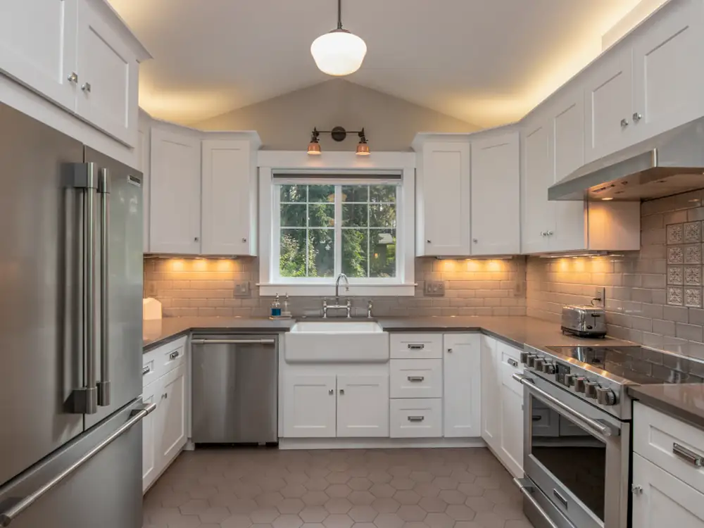 Bright white kitchen with under-cabinet lighting and pendant light