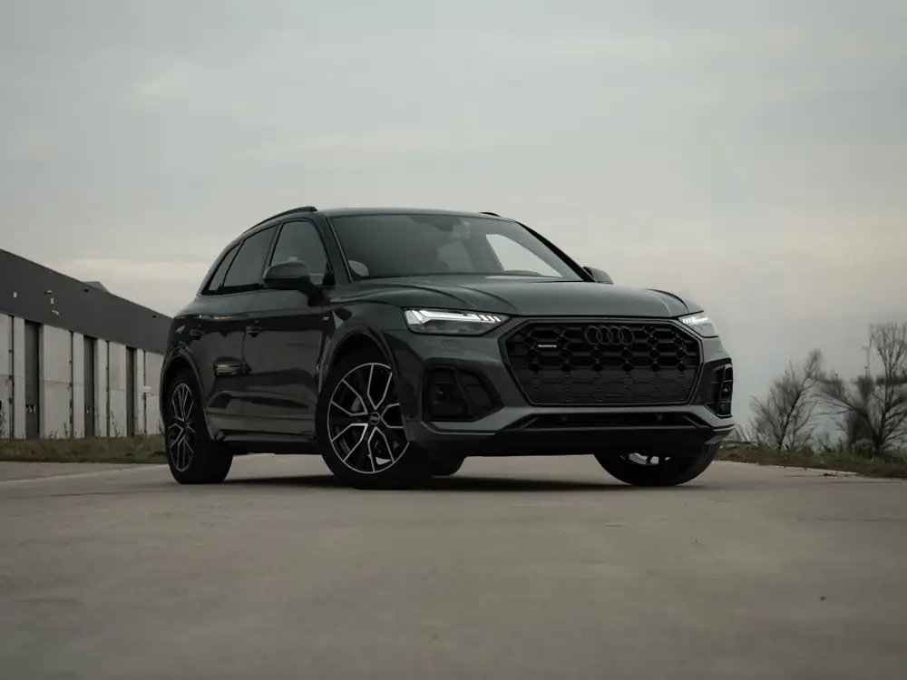 Dark grey SUV parked on concrete, glossy after a ceramic coating