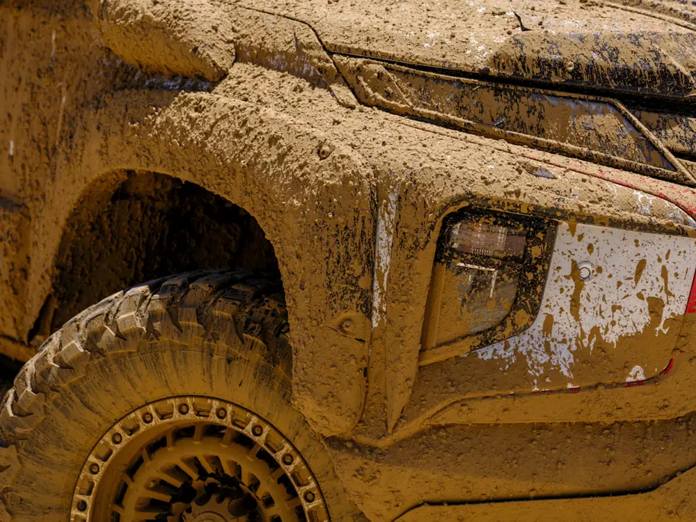 Close-up of a mud-caked 4WD wheel with a mud-terrain tyre