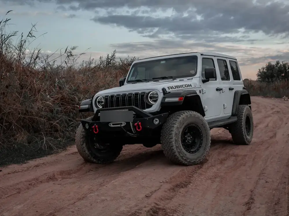White Wrangler Rubicon on big all-terrain tyres on a dirt road