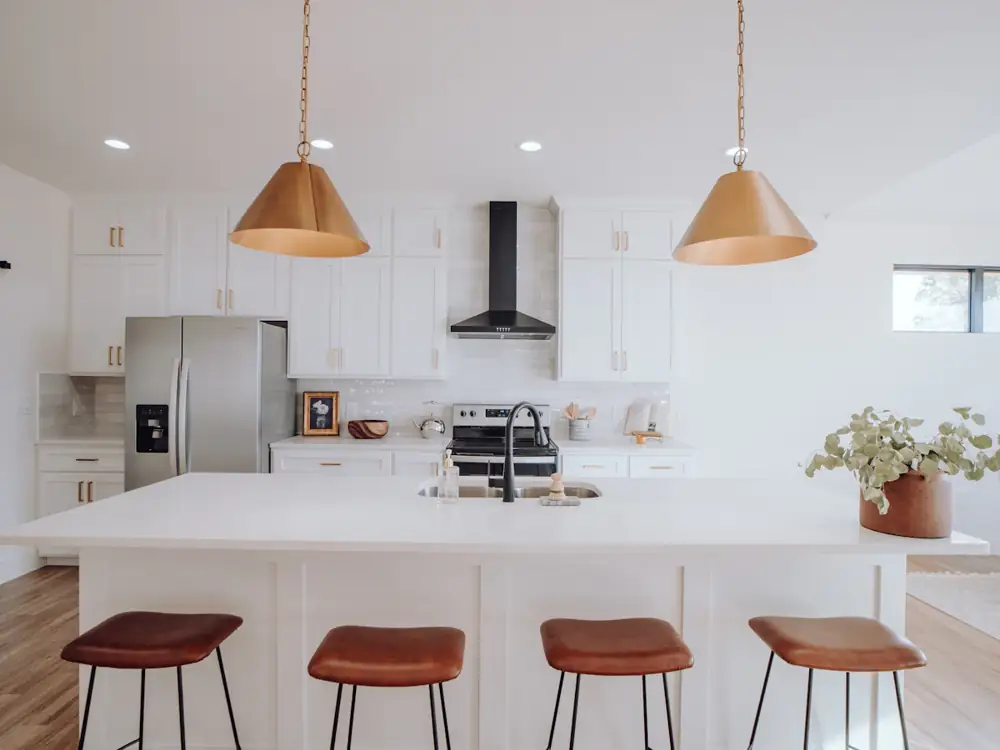 Bright white kitchen with copper pendant lights over the island