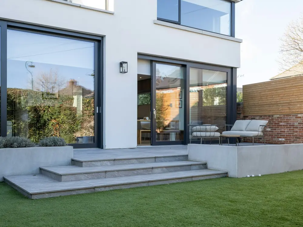 Wide grey porcelain entry steps leading up to a white home