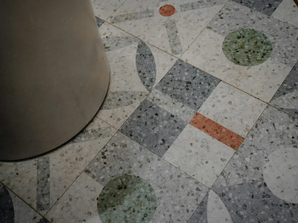 Terrazzo floor tiles with grey, green and terracotta chips