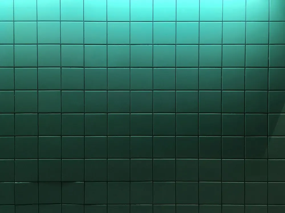 Square green tiles laid in a stack bond grid