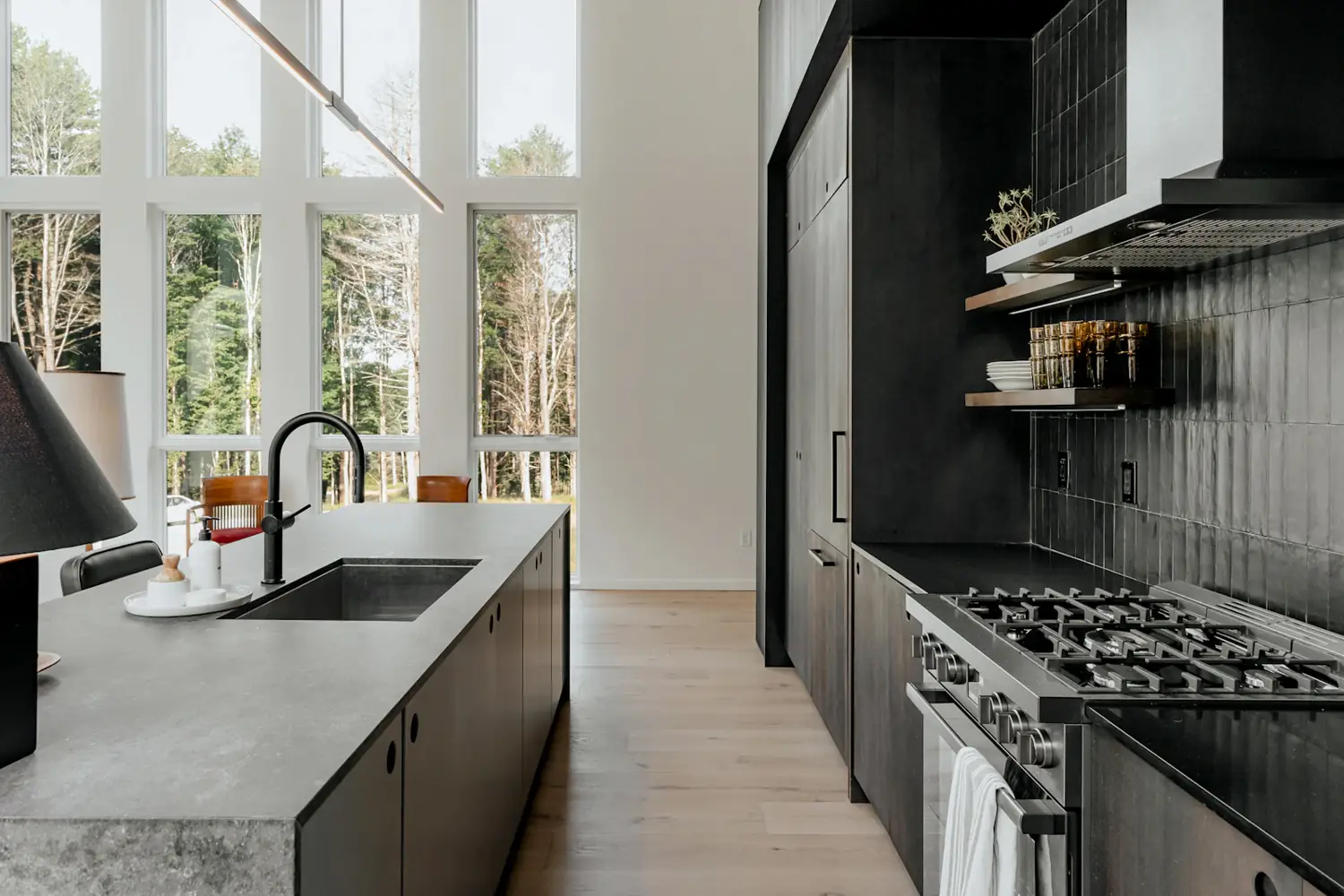 Finished renovation: a charcoal kitchen with a concrete-look island, black tapware and full-height windows