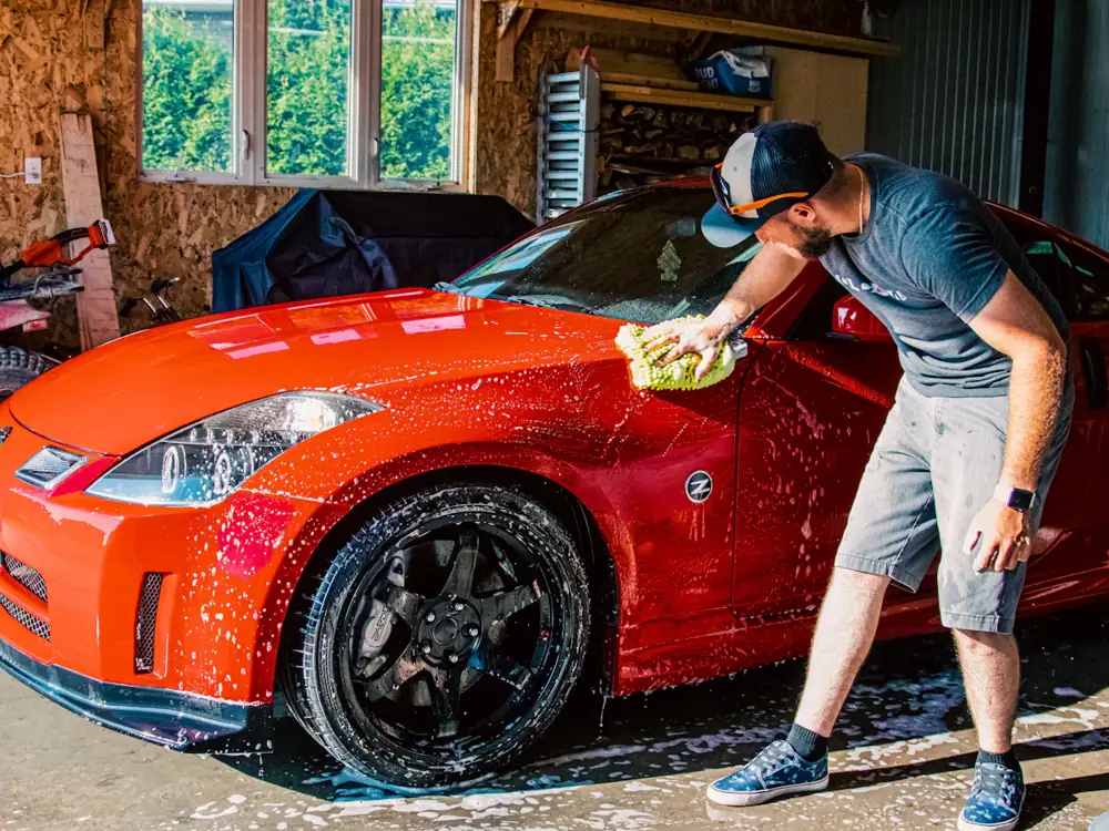 Red sports car being hand washed