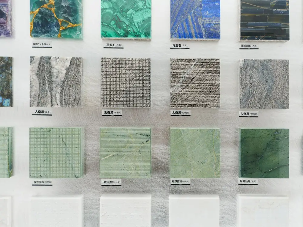 A wall of stone and tile samples in greens, greys and blues