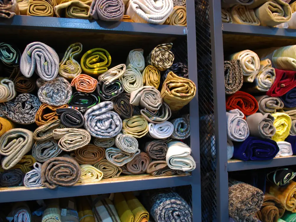 Shelves stacked with rolls of colourful fabric