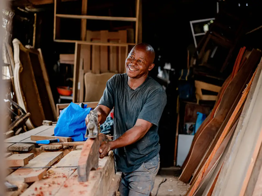 Dan smiling as he saws timber in his workshop
