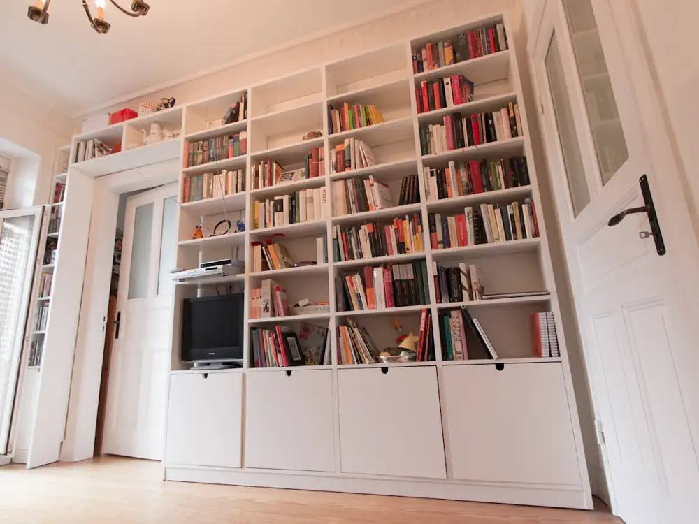 Floor-to-ceiling white built-in bookshelves around a doorway