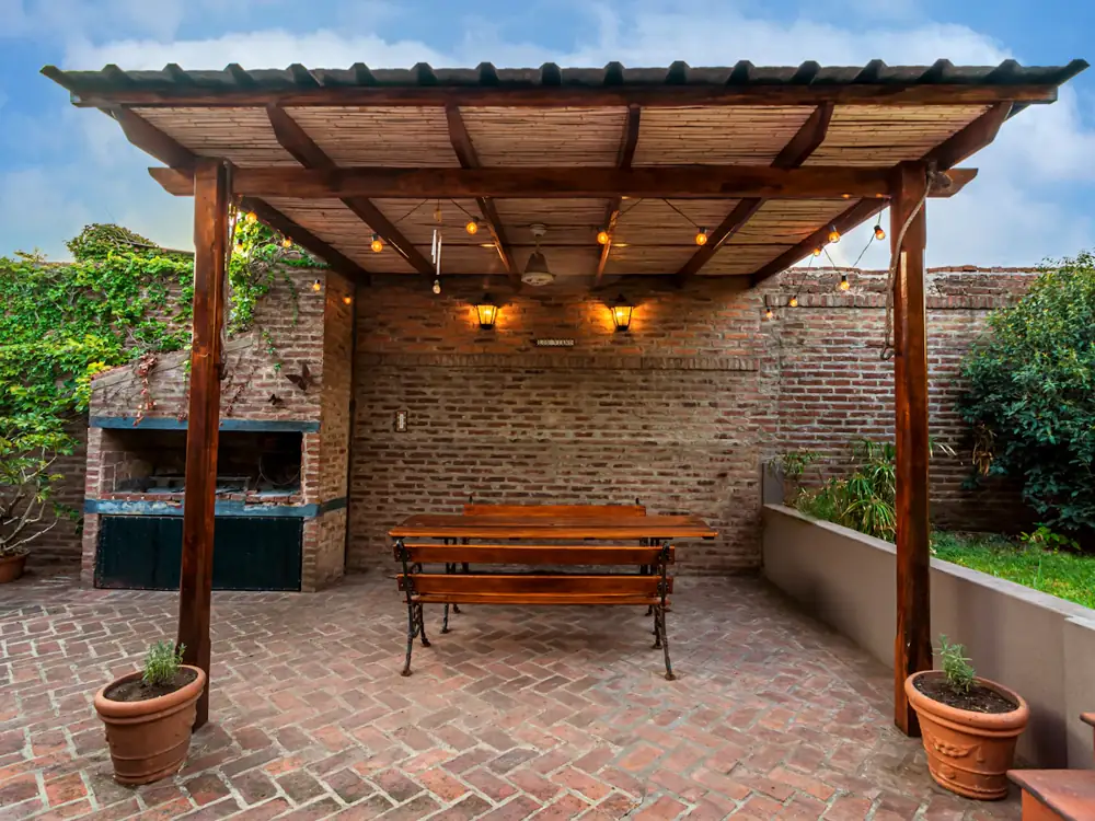 Timber pergola posts and beams over a brick courtyard